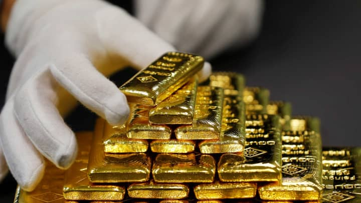 Gold Declines, Yet Poised to Log Third Monthly Gain Despite Dollar Rally